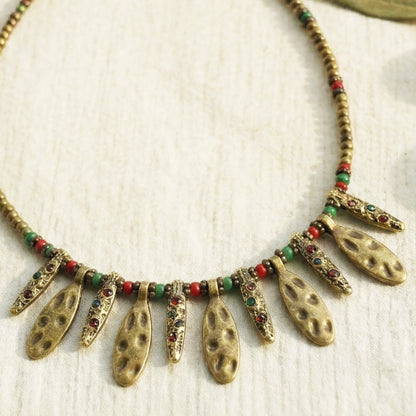 Necklace with gold and multicolored beads on a light background