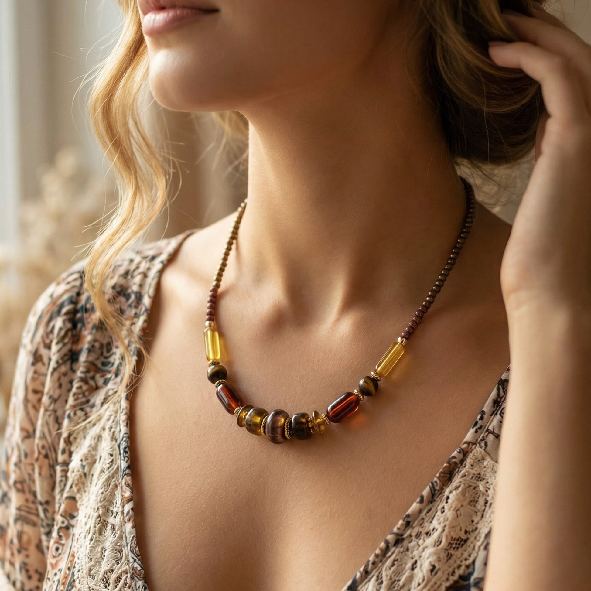 Close-up of a woman wearing a beaded necklace with a neutral background