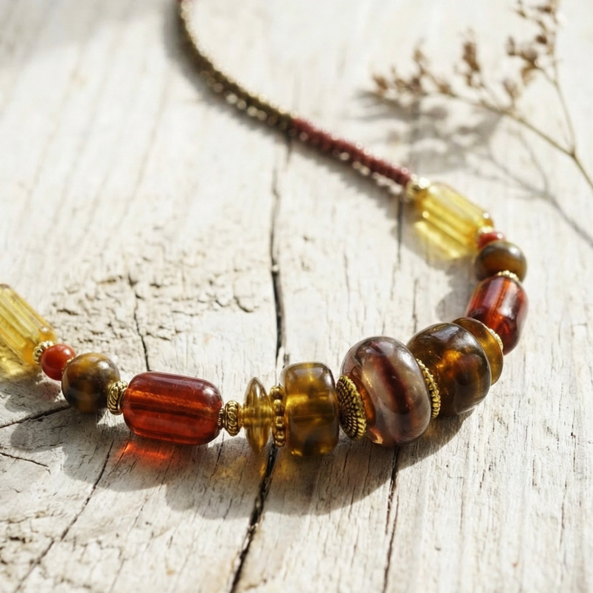 Beaded necklace with amber and brown beads on a wooden surface
