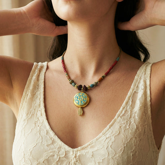 Close-up of a woman wearing a colorful beaded necklace with a decorative pendant.