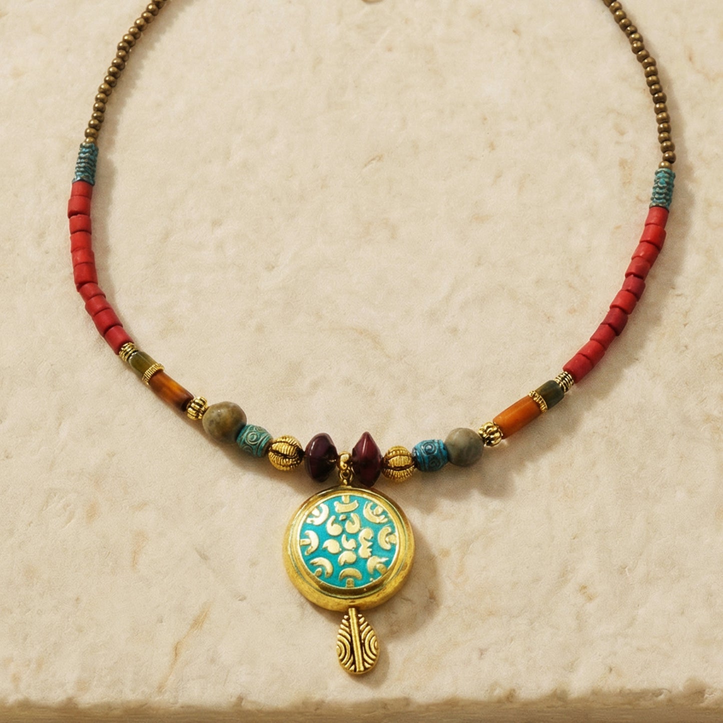 Necklace with colorful beads and a decorative pendant on a beige background