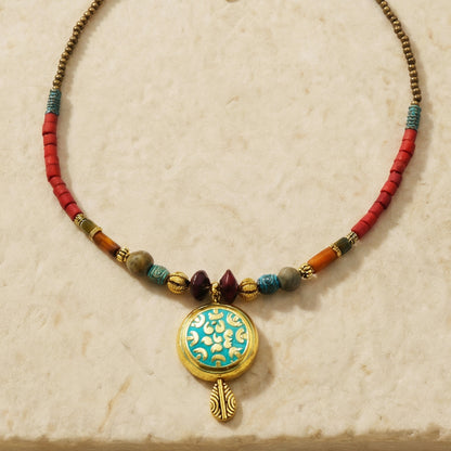 Necklace with colorful beads and a decorative pendant on a beige background