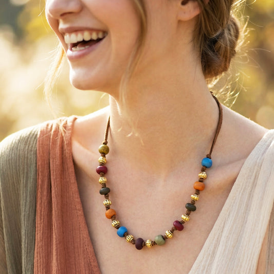 Woman wearing a colorful beaded necklace with a blurred natural background