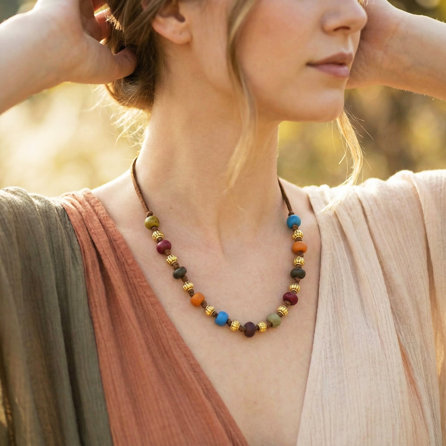 Woman wearing a colorful beaded necklace with a blurred natural background