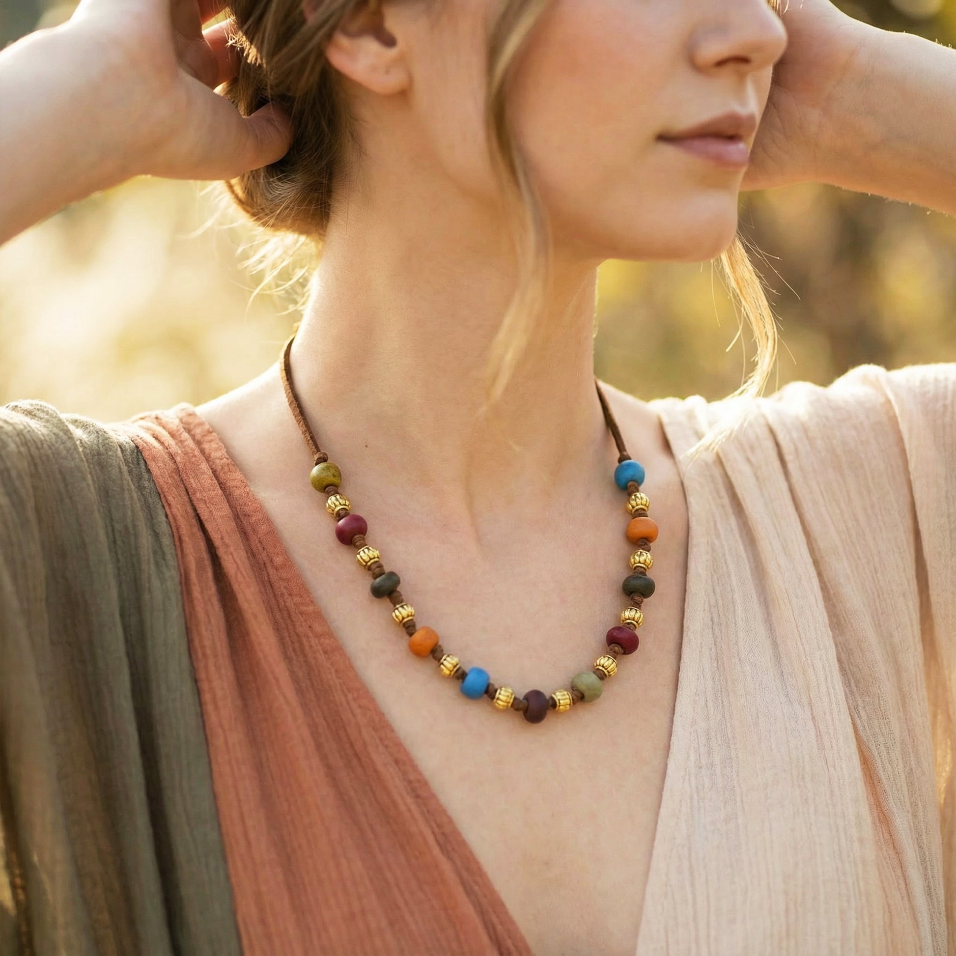 Woman wearing a colorful beaded necklace with a blurred natural background