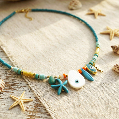 Necklace with starfish and shell decorations on a textured surface with starfish and shells.