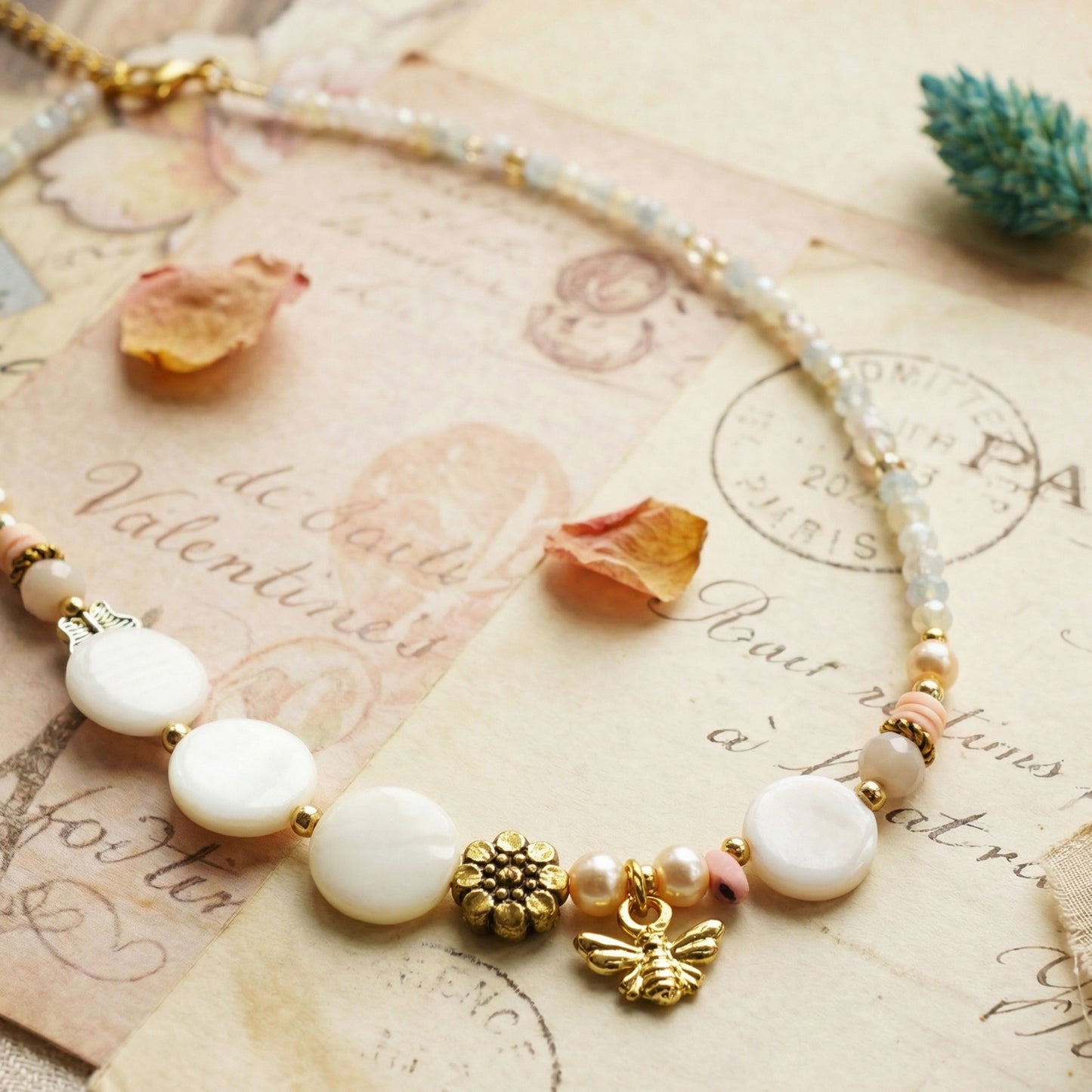 Necklace with white beads and gold accents on an old letter background