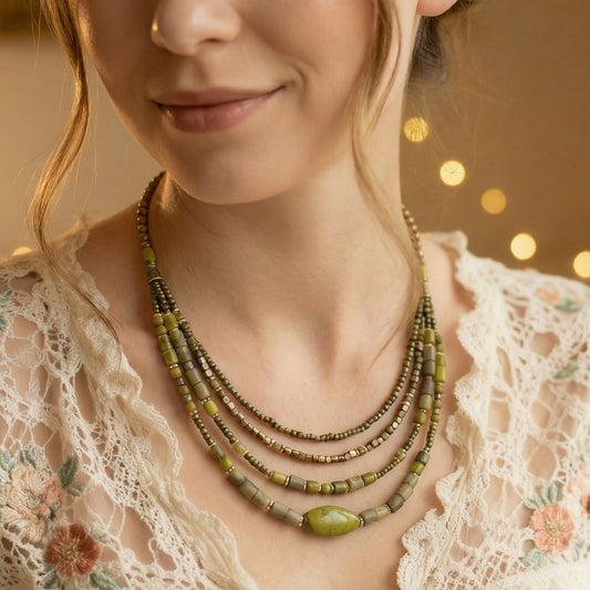 Close-up of a woman wearing a layered beaded necklace with a blurred bokeh background