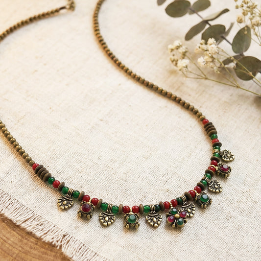 Decorative necklace with beads and pendants on a textured fabric background