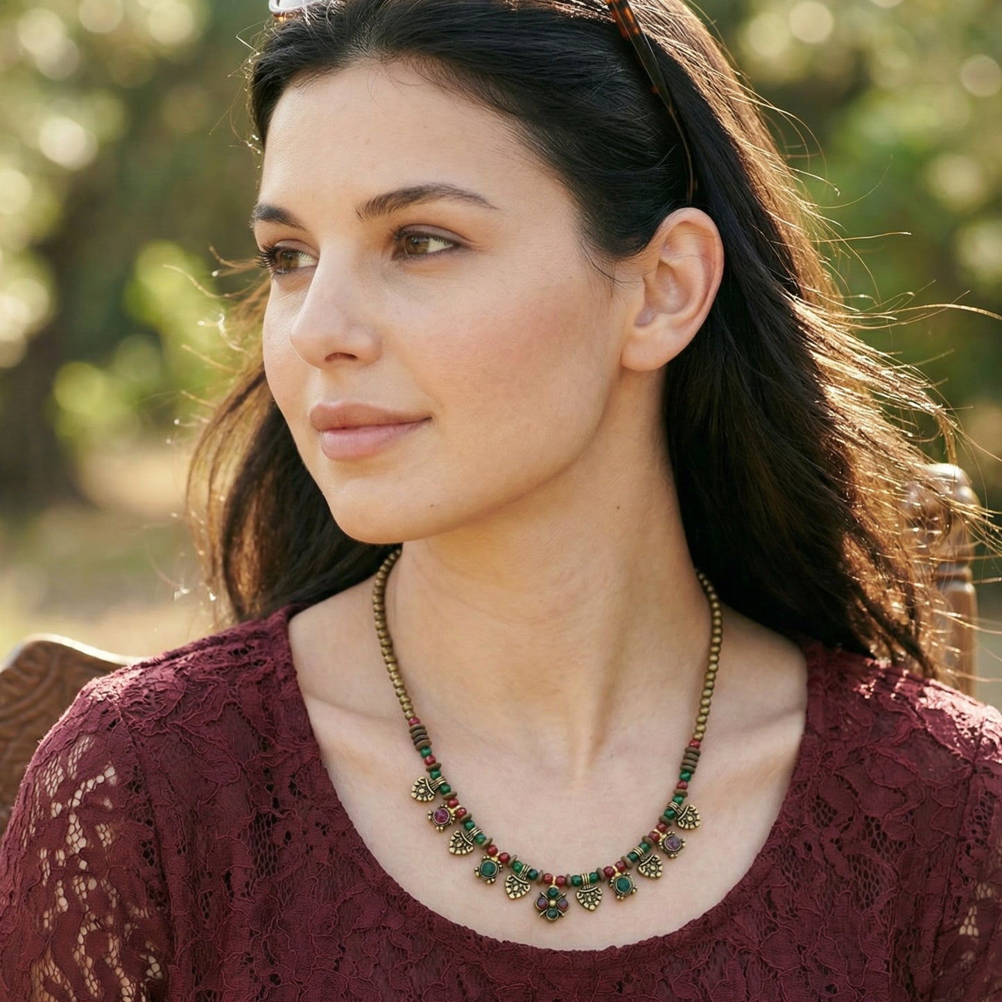 Woman wearing a necklace with a blurred natural background