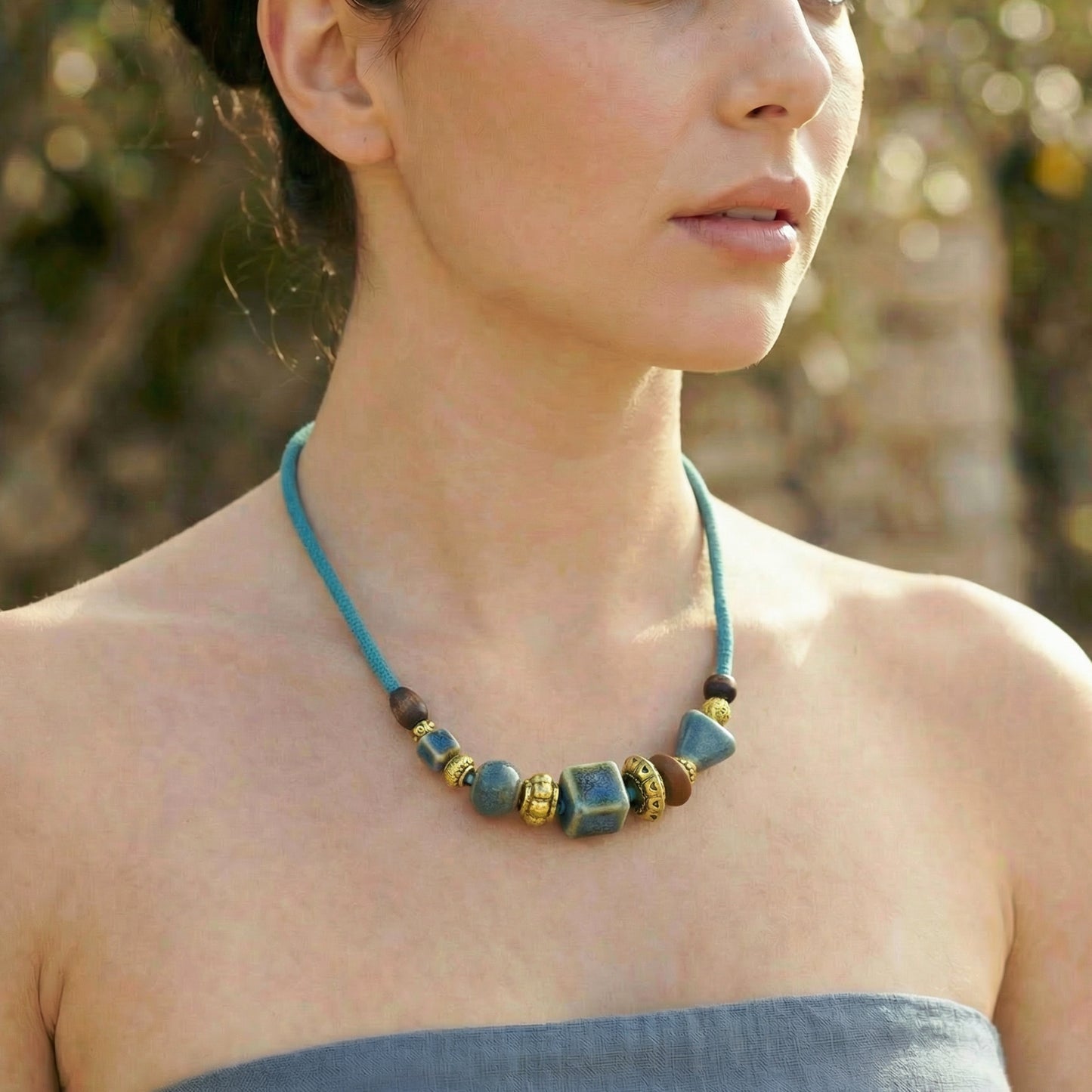 Woman wearing a blue beaded necklace outdoors
