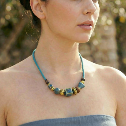Woman wearing a blue beaded necklace outdoors