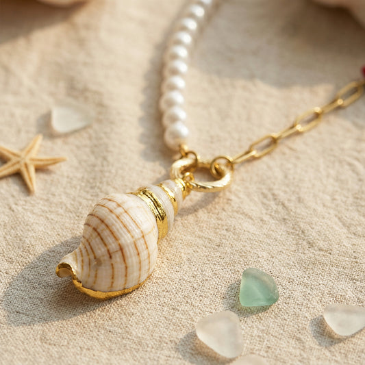 Necklace with a shell pendant on a sandy background