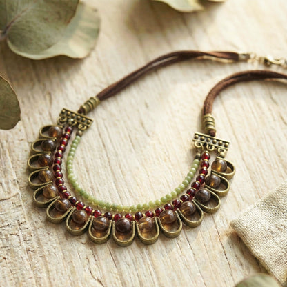 Necklace with beads and metal accents on a wooden surface