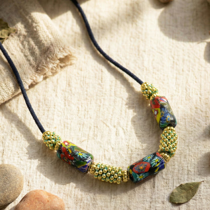 Colorful beaded necklace on a textured fabric background