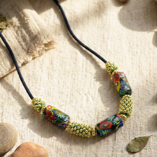 Colorful beaded necklace on a textured fabric background