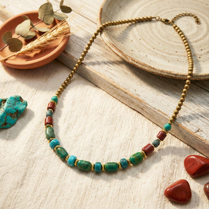 Necklace with green and red beads on a wooden surface with natural elements