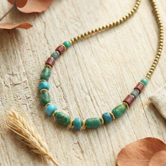 Necklace with turquoise and red beads on a wooden surface