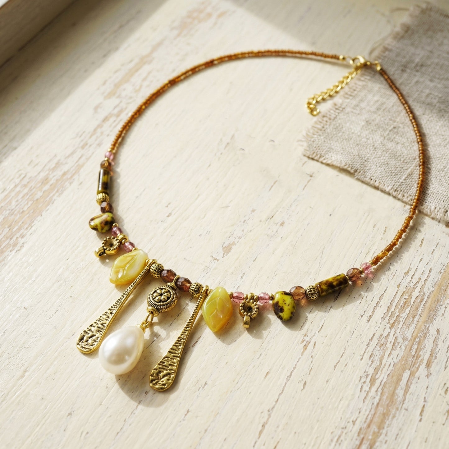 Necklace with beads and pendants on a wooden surface