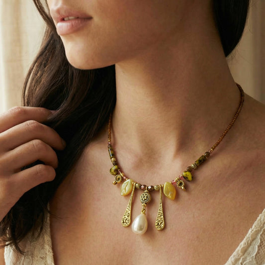 Close-up of a woman wearing a detailed necklace with yellow and gold beads.