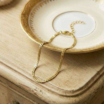 Gold bracelet on a decorative plate with a wooden surface