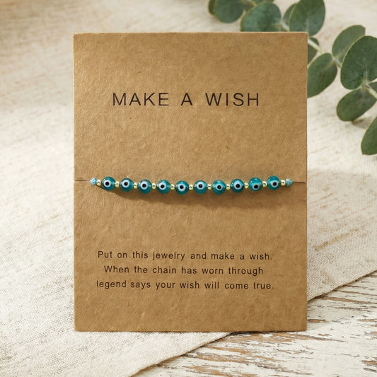 Bracelet with blue beads on a 'Make a Wish' card with text.
