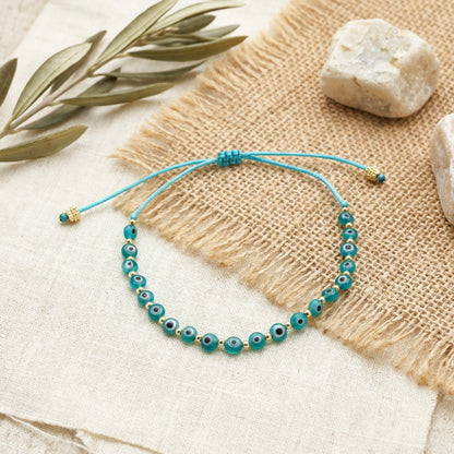 Turquoise beaded bracelet on a textured surface with stones and leaves