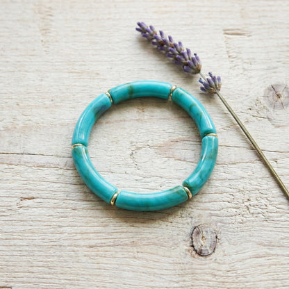 Turquoise bracelet on a wooden surface with lavender flowers