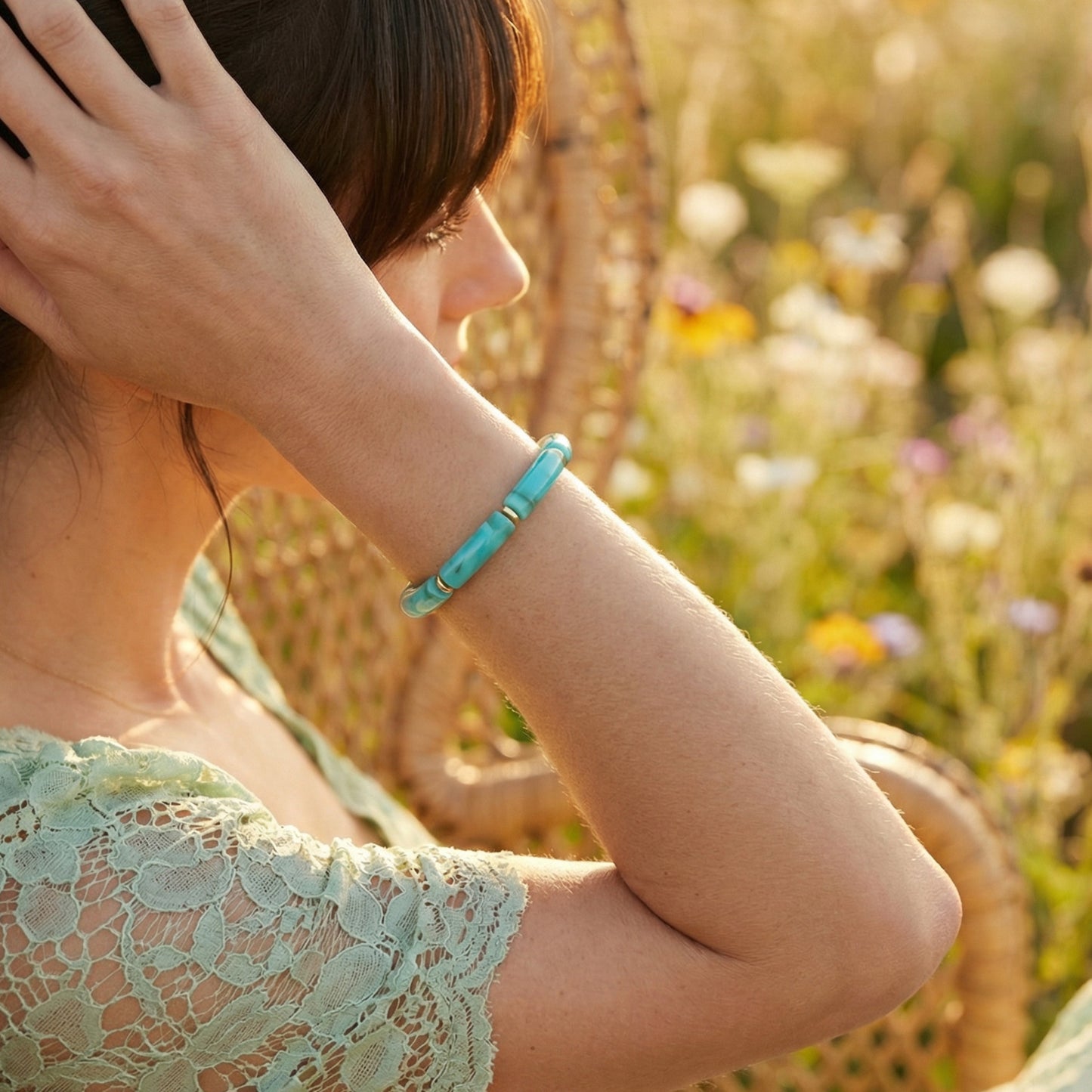Woman wearing a turquoise bracelet in a field of flowers