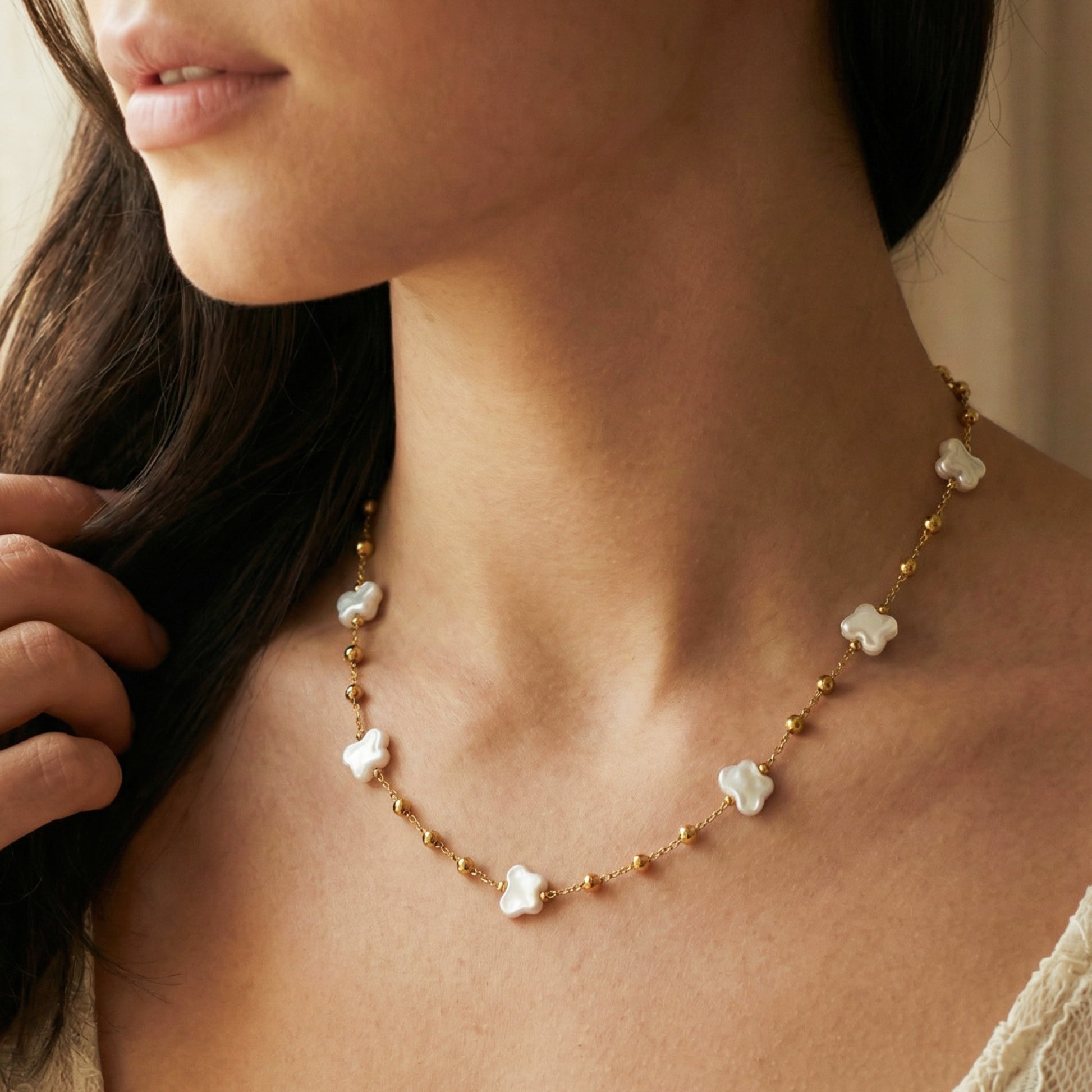 Close-up of a woman wearing a delicate necklace with floral pendants.
