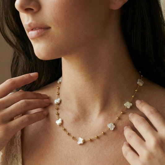 Woman wearing a delicate pearl necklace with gold accents