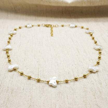Gold bracelet with pearls on a beige fabric background