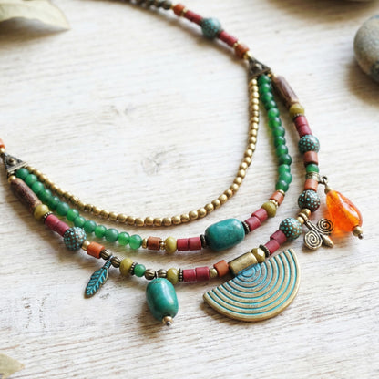 Colorful beaded necklace with various beads and a large turquoise pendant on a light wooden surface.