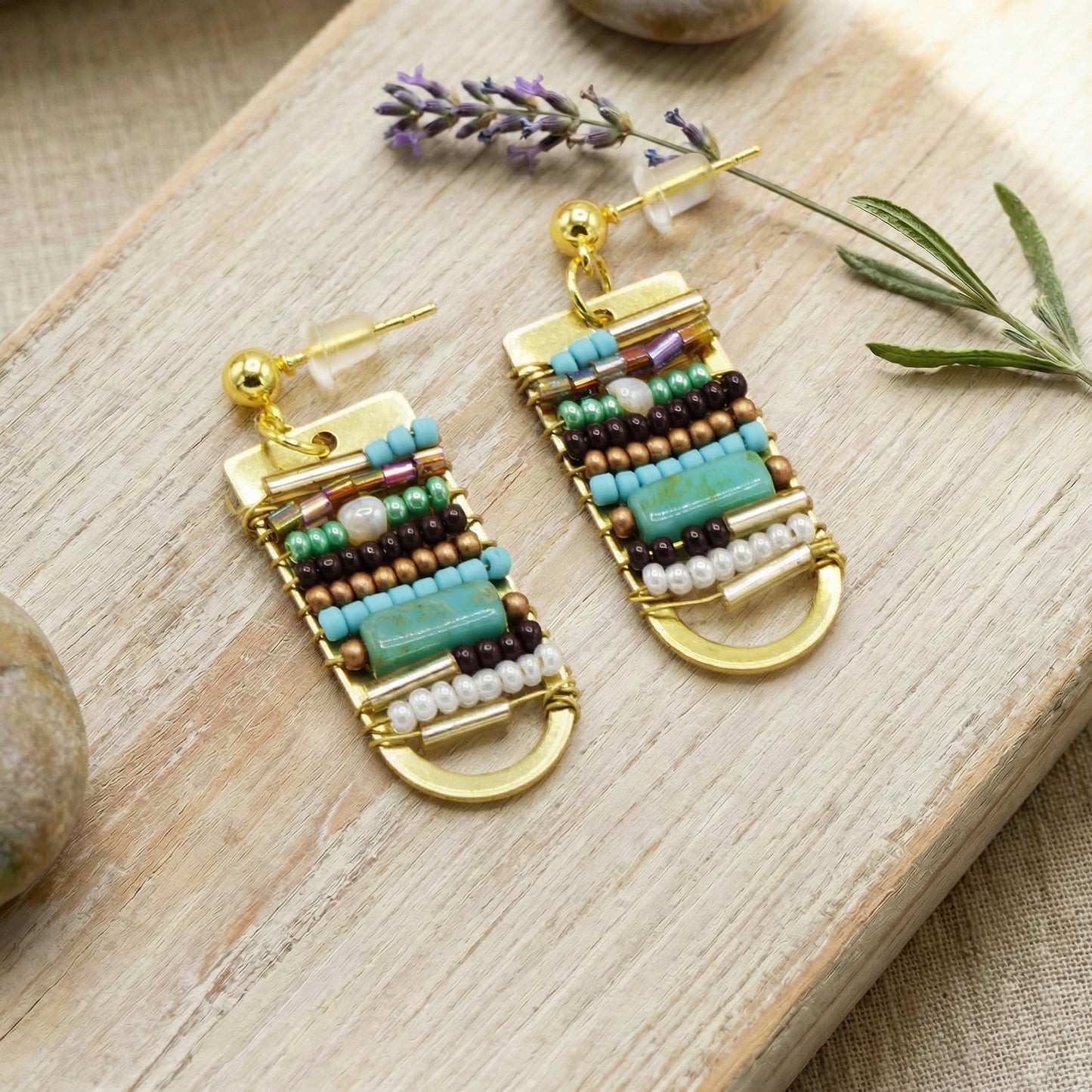 Beaded earrings on a wooden surface with lavender flowers