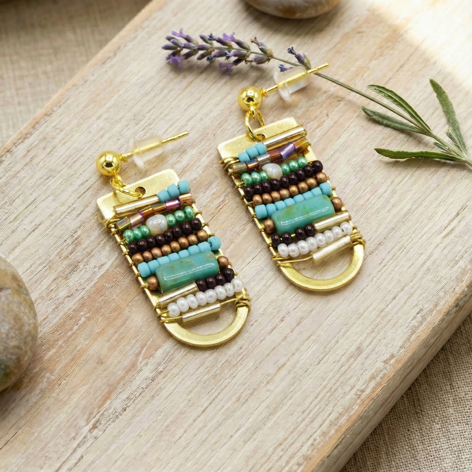 Beaded earrings on a wooden surface with lavender flowers