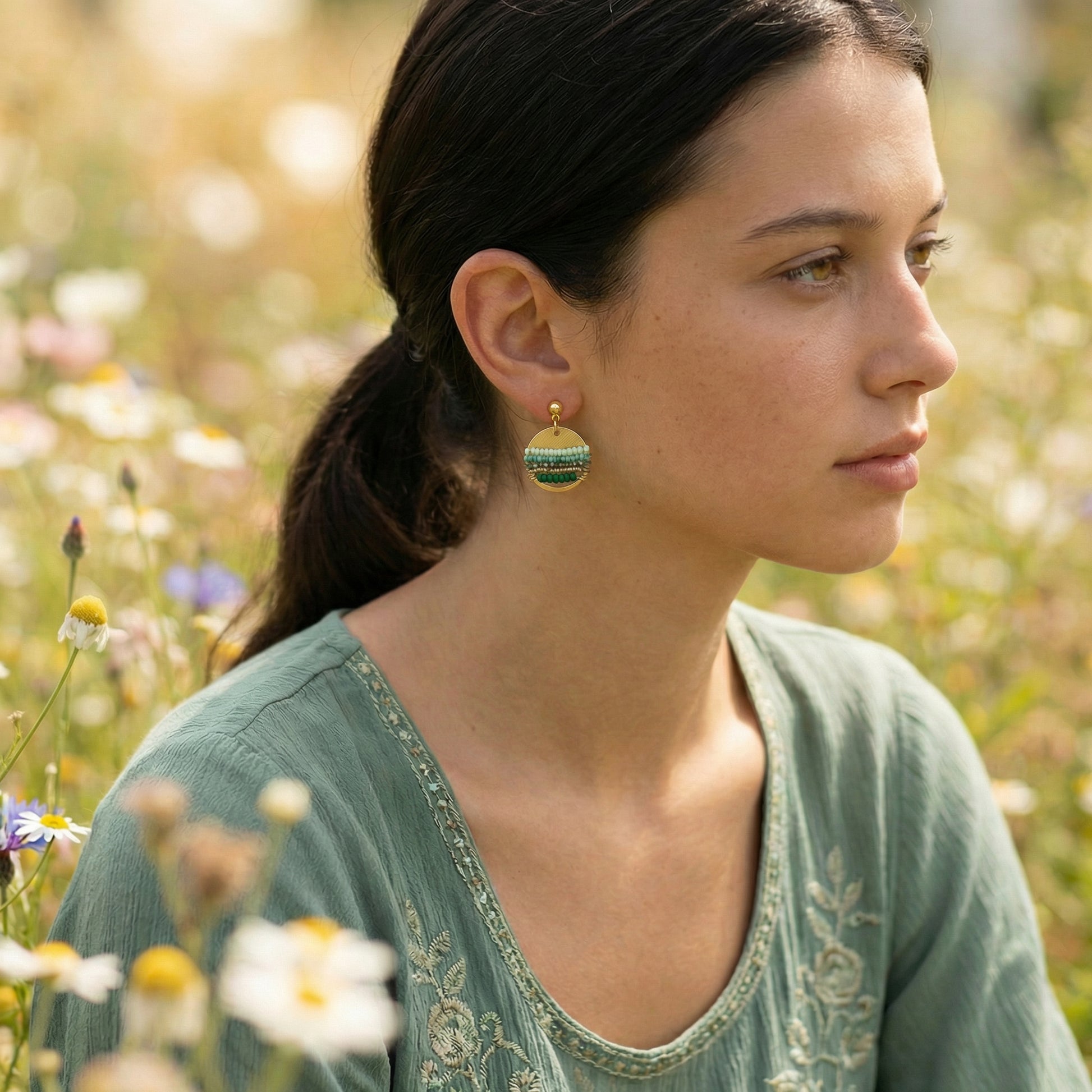 Woman wearing earrings with a blurred natural background