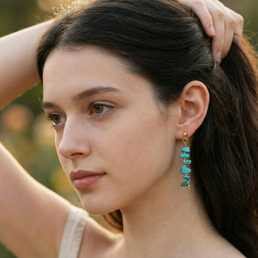Woman wearing turquoise earrings with a blurred natural background