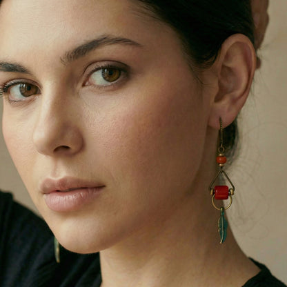 Close-up of a woman wearing an earring with red and green details.