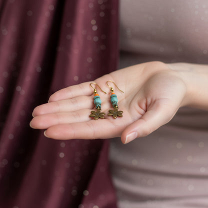 Hand holding a pair of earrings with a blurred background